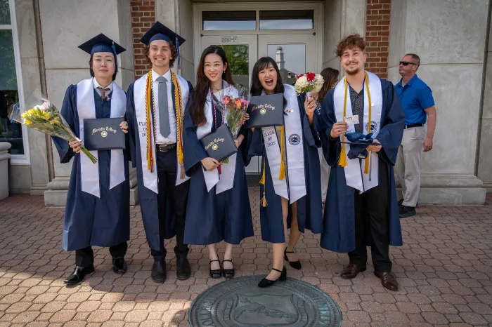 Graduates from 2025 stand proudly with their diplomas