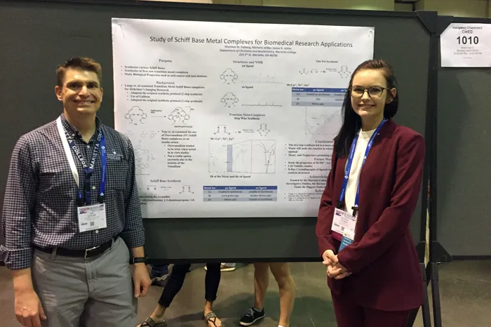 Dr. Jim Jeitler and Shannon Patberg standing in front of a research poster