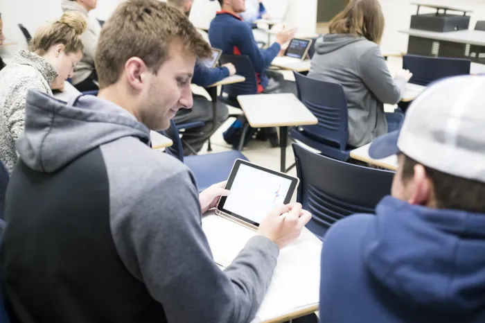 Students looking at an iPad in class