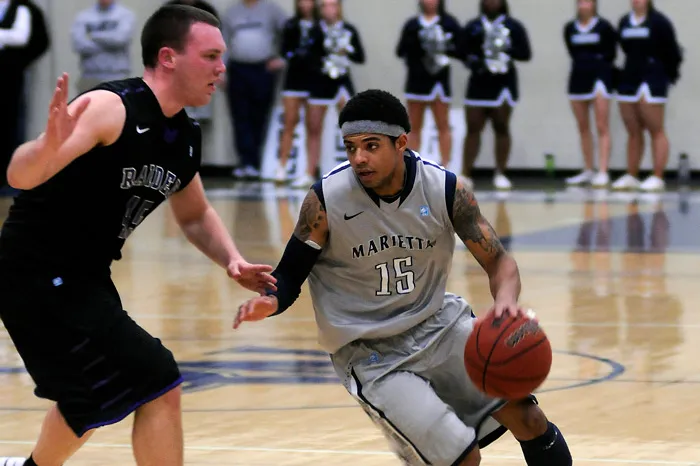 Tyler Hammond dribbles the basketball around a Mount Union defender during his Marietta College playing career