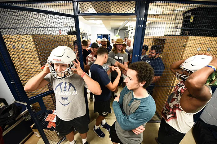 Marietta football players trying on helmets