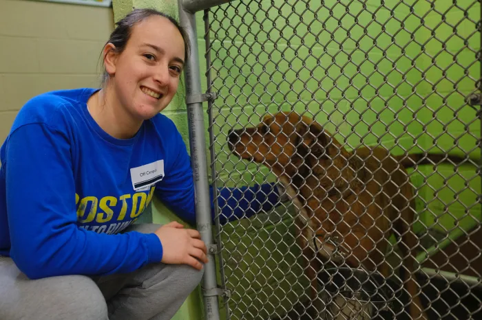 Female student petting a dog at the humane society