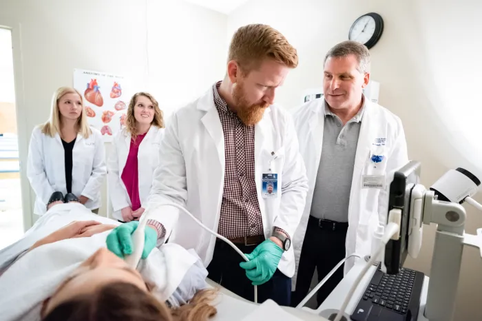 A PA professor working with students on an ultrasound procedure