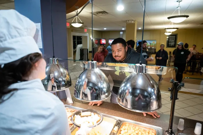 Male student waiting to be served breakfast