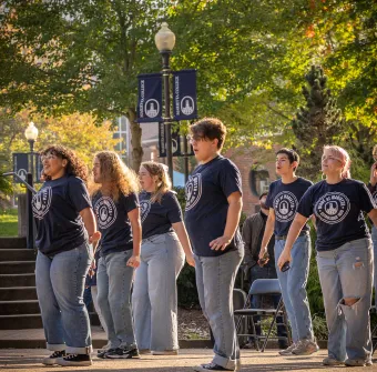 Group of theatre students perform outdoors during Homecoming 2025