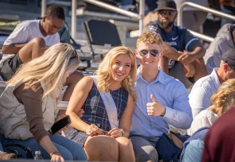 Homecoming Queen Bre Herrick poses with male alumnus in stands