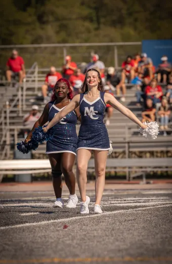 Two cheerleaders cheer during 2025 Homecoming Football Game