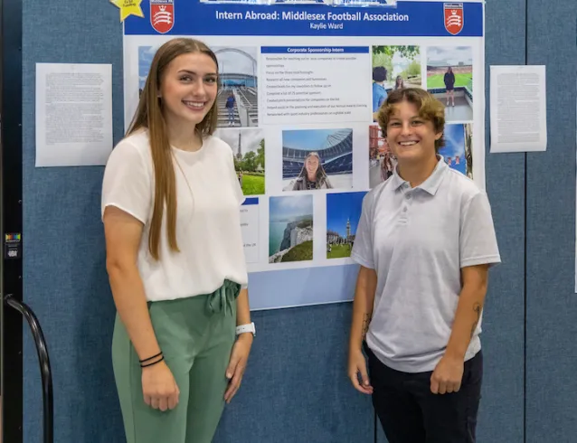 Marietta College students pose in front of a poster during Experiential Education Day