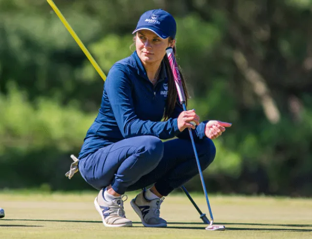 Helena Immel crouched down on a golf course