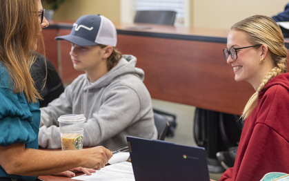 Professor and two students converse during class