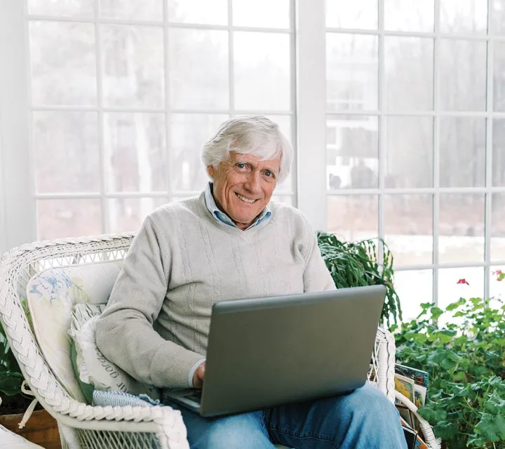 Pual Adams '69 sitting and working at a computer