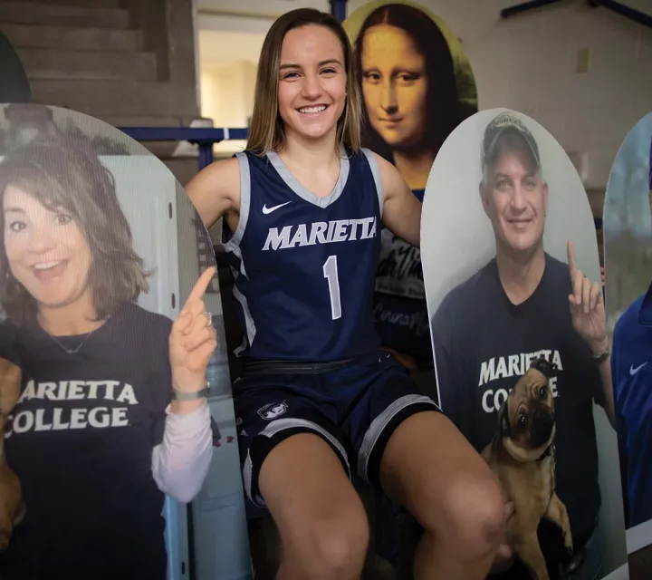 Kate Liston poses in the stands with fan cutouts