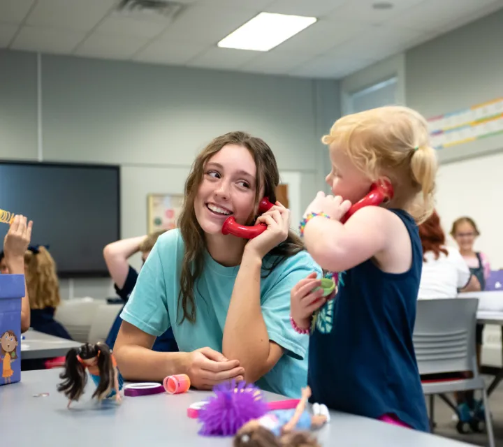 A Marietta College Education student plays telephone with an early elementary child