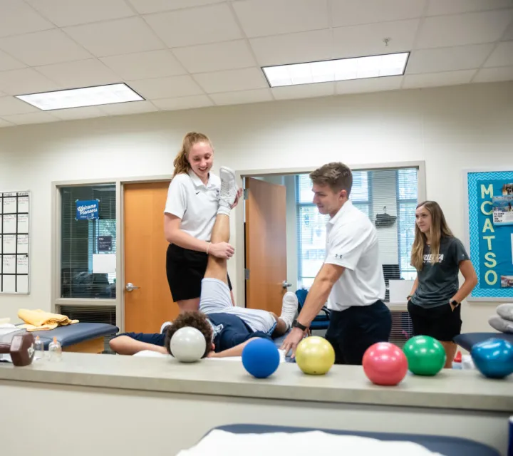 A Sport Medicine student at Marietta college works with a student athlete in a training room