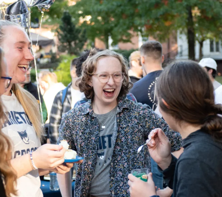Female students eating and smiling