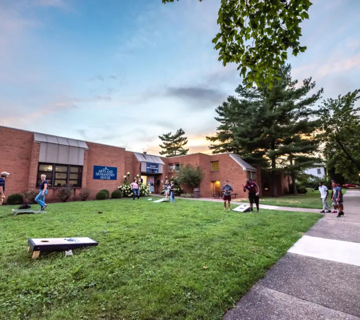 Students playing cornhole in front of the Barbara Diggs Lyles House and Multicultural Center