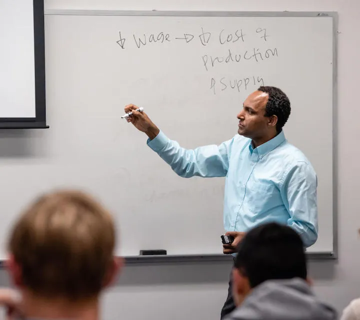 Professor Bizuayehu Bedane teaching business majors during and econ class