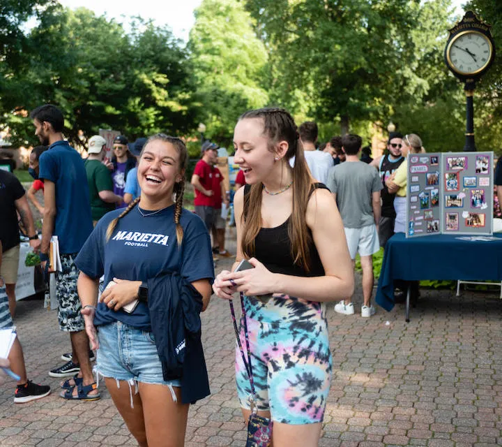 Two Marietta College students laugh during the Campus Involvement Fair