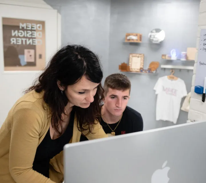 Graphic design professor Sara Rosenstock works with a student in the Deem Design Center