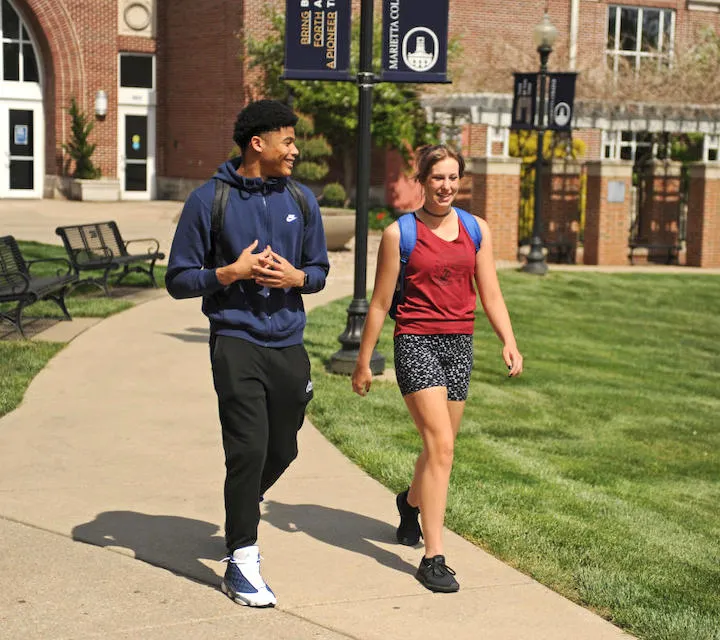 Two Marietta College students walking outside Legacy Library