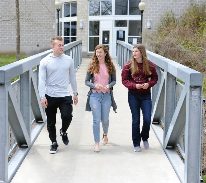 Students walking across the McCoy bridge