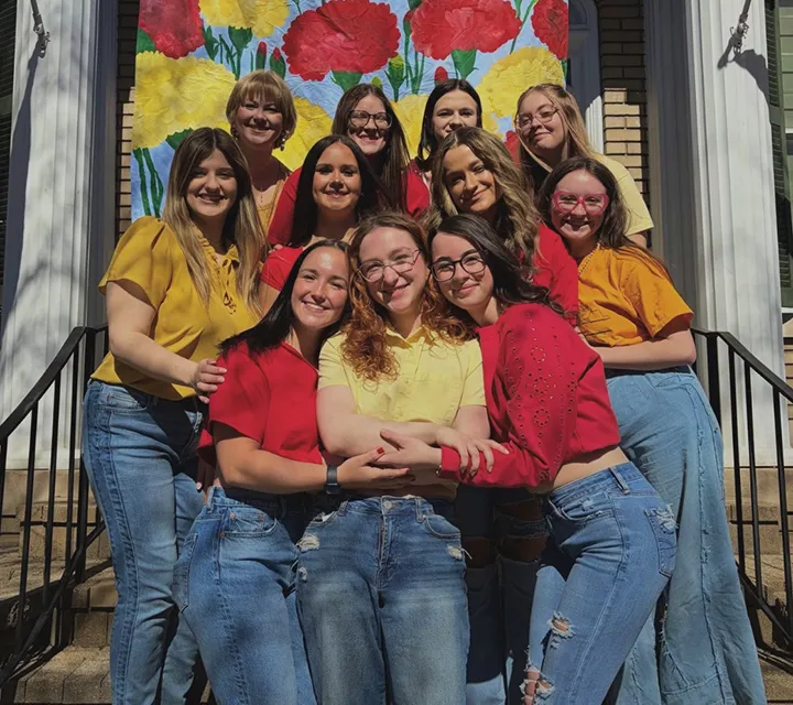 Members of Chi Omega sorority gathered on the steps of the Chi-O house
