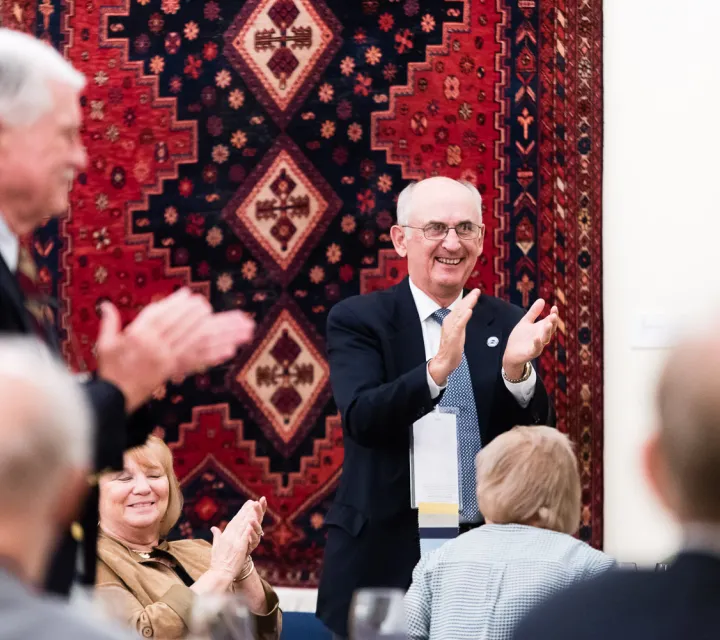 member of the Class of 1966 claps after a speech at their homecoming banquet