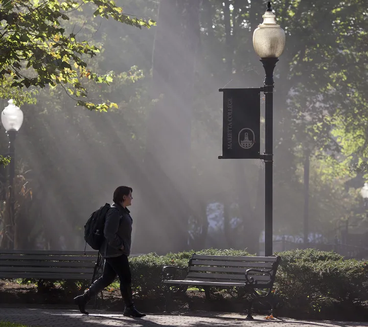 Student walks on the Mall with sun rays in the early morning