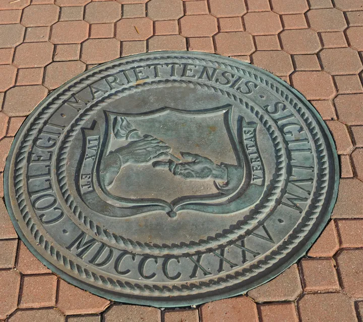 The Marietta College Seal in the brick ground outside of the Legacy Library