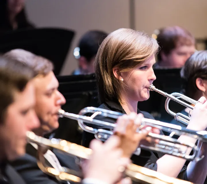 Female student playing trumpet at a concert