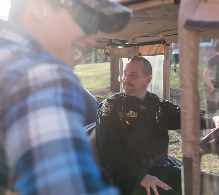 Campus police officer hangs out with students behind Marietta Hall