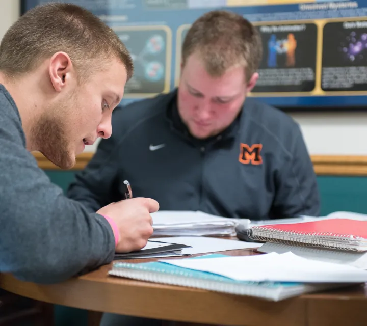 two students study in one of the lobbies of the science building