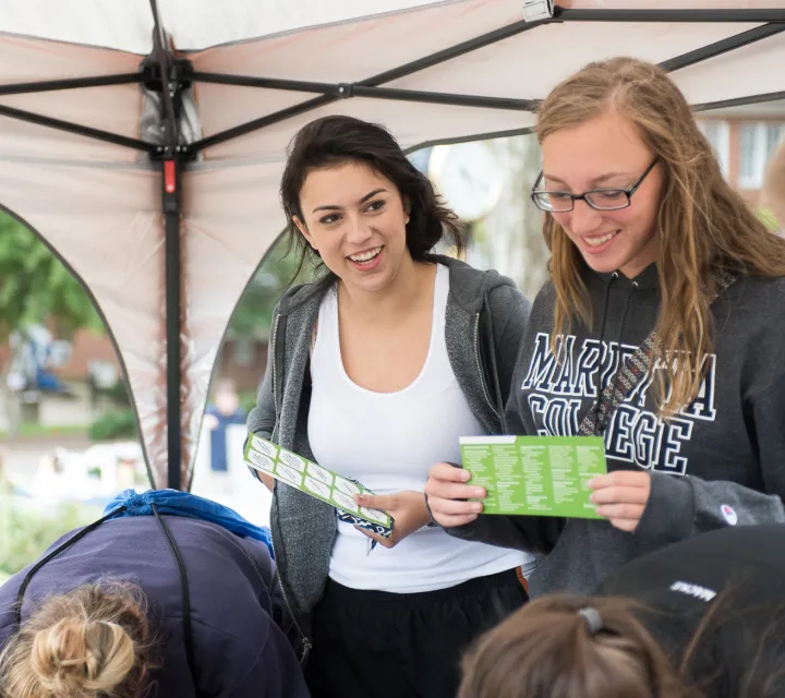 Two students submitting papers at the Involvement Fair