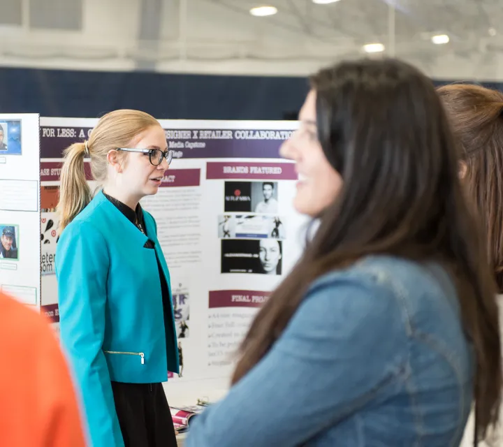 Student gives poster presentation at All Scholars Day