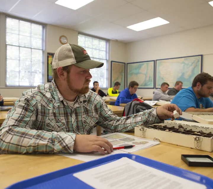 Student checks out a rock in a classroom