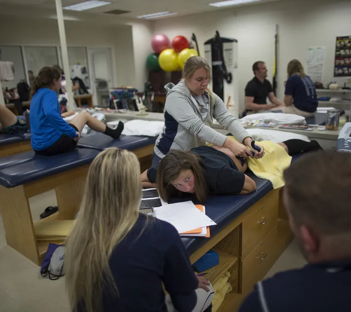 Athlete being helped by athletic trainer