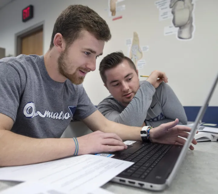 Two Athletic Training students work on a computer