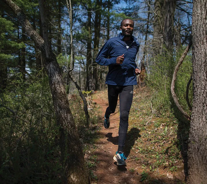 Marietta College admission counselor Makorobondo “Dee” Salukombo runs down a forest trail