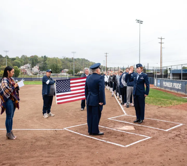 Brittany Curry '15 raises her hand on the Marietta Softball Field during her promotion ceremony