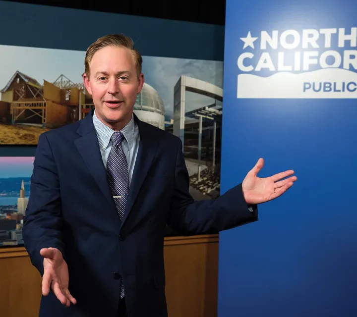 Darren LaShelle '89 poses in front of a Northern California Public Media Banner