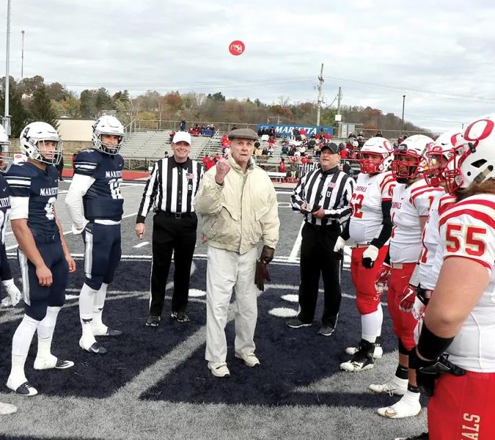 Richard McNally '53 flips the coin at a Marietta College football game