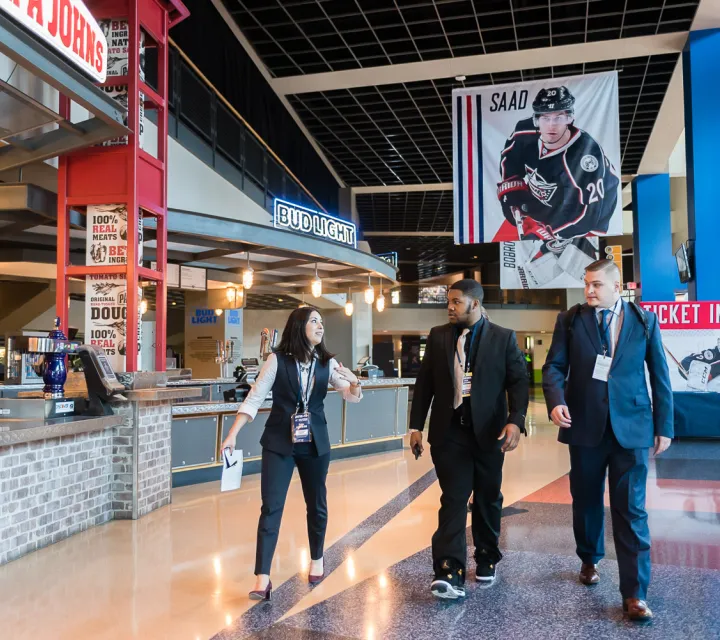 Rob Hennings ’20 and John Jaeckin ’18 meet with a Columbus Blue Jackets employee to learn what they will be doing during their job shadow experience