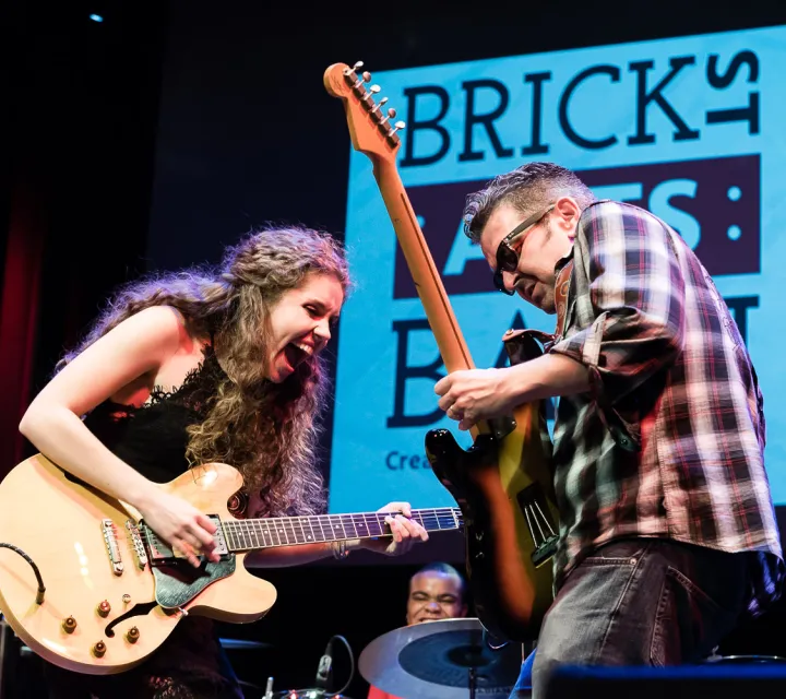 Marietta College Student Sadie Johnson Plays Guitar at the first Brick Street Bash