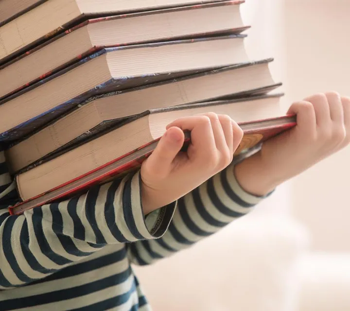 Stock photo of girl holding and carrying books