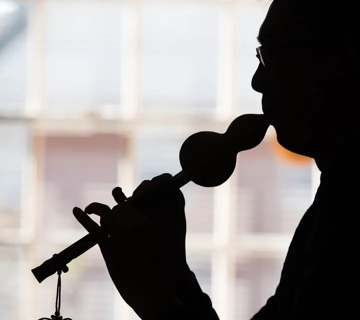 International Student plays a traditional woodwind instrument