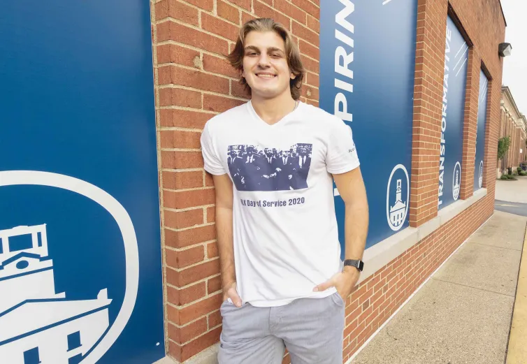 Artemii Stepanets, a Marietta College student, leans against a brick wall