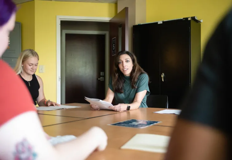 Dr. Ali Doerflinger sitting at a table with students