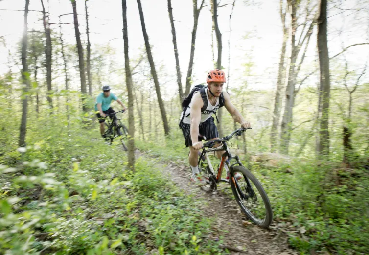 A Marietta College student mountain bikes down a trail