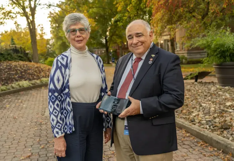 Greg Maloof ’67 holding his Distinguished Alumnus Award
