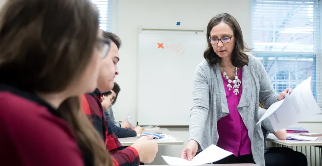 Female faculty member handing back an assignment to a student